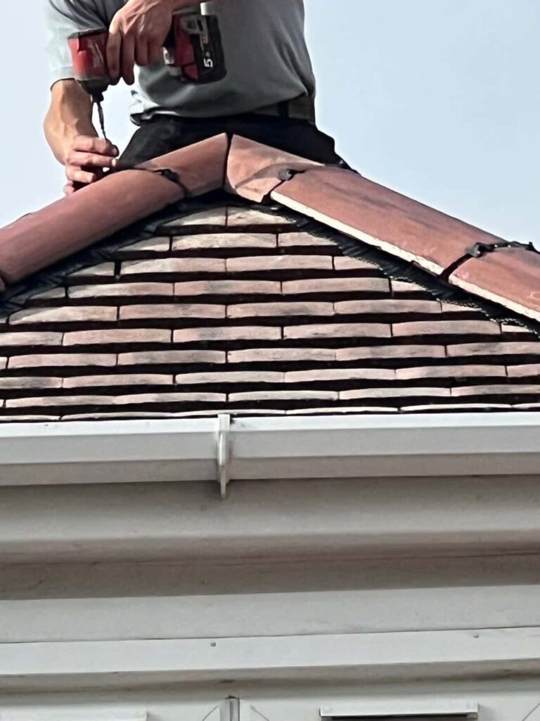 This is a photo of one of the operatives of Portsmouth Roofing Repairs installing new ridge tiles